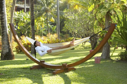 Woman relaxing on hammock at exotic surrounding at bali indonesia